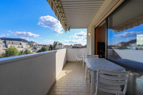 安錫的住宿－La Pause annécienne appartement familial，设有一个配有桌椅并享有美景的阳台。