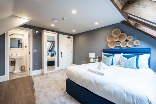 a bedroom with a large bed with a blue headboard at Old Abbey House in Abingdon