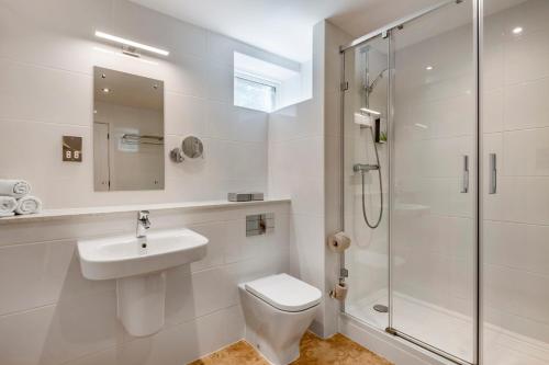 a bathroom with a toilet and a sink and a shower at Thurnham Hall Resort in Cockerham