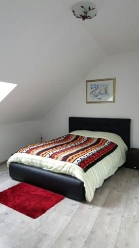 - un lit dans une chambre dotée d'un tapis rouge dans l'établissement Maison 4 pièces, 3 chambres avec Jardin et Terrasse, à Lisses