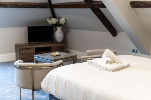 a bedroom with a bed and a tv and a chair at Old Abbey House in Abingdon