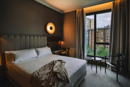 1 dormitorio con cama y ventana grande en Hotel Pinar Plaza, en Madrid