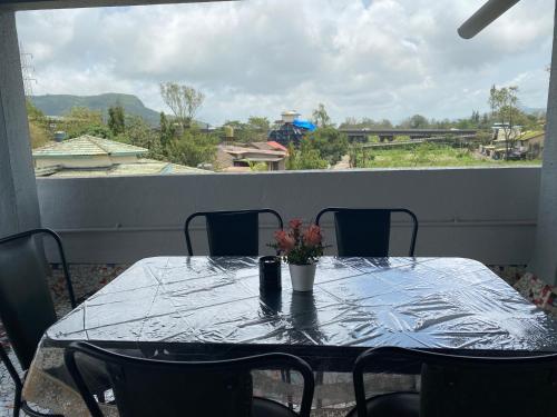 - une table avec un vase de fleurs sur le balcon dans l'établissement Mystic Dreamville 3BHK Villa Lonavala, à Lonavala