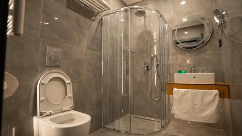 a bathroom with a shower with a toilet and a sink at KAME HOTEL BELGRADE,贝尔格莱德凯美酒店 in Ledine