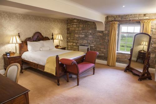 a bedroom with a bed and a table and chairs at Thurnham Hall Resort in Cockerham