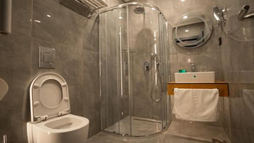 a bathroom with a shower and a toilet at KAME HOTEL BELGRADE,贝尔格莱德凯美酒店 in Ledine
