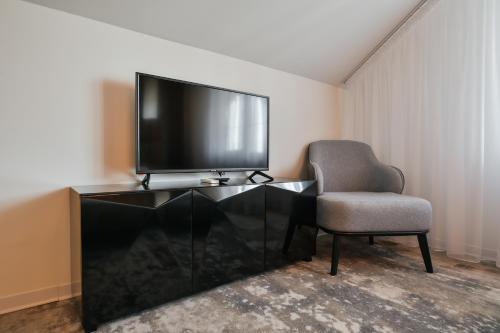 a living room with a television and a chair at Садиба на Кодимі in Archipitovka