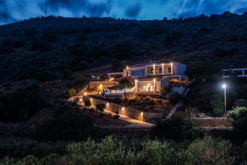 a house on a hill at night with lights at Elounda Sunshine Place in Elounda