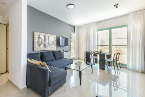 ein Wohnzimmer mit einem Sofa und einem Tisch in der Unterkunft Elegant Sea-View Apartment with Mamad in the Heart of Tel Aviv by Sea N' Rent in Tel Aviv