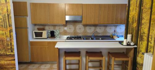 a kitchen with a sink and a counter with stools at Casa Giada in Rapallo