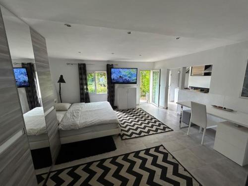 une chambre avec un lit, un bureau et une table dans l'établissement Mougins Village grand studio, avec piscine vue mer partagée, à Mougins