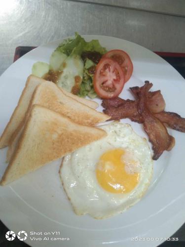 a plate of breakfast food with eggs bacon and toast at MinshukuKCS Hotel and Restaurant in Puerto Galera