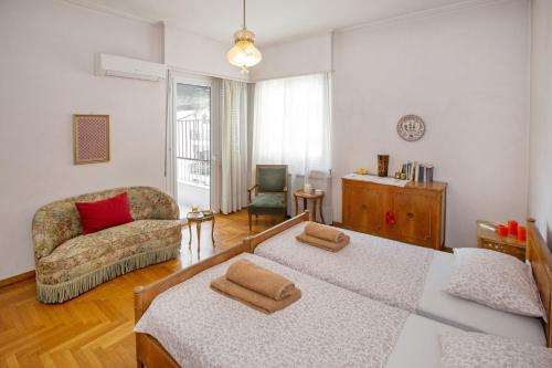 ein Wohnzimmer mit einem Sofa und einem Stuhl in der Unterkunft Vintage apartment KOLONAKI in Athen