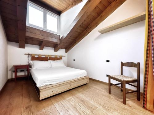 una camera con un letto e una sedia e una finestra di UR NEST Ceneri a Bologna