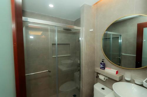 a bathroom with a shower and a sink and a mirror at Gloria Tree Mayon and Park View Residences in Legazpi