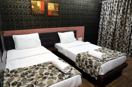 two beds in a hotel room withskirts at Hotel Pearls in Aurangabad