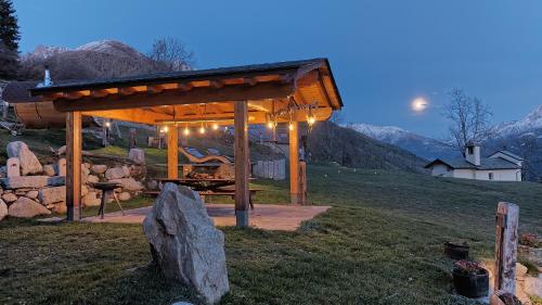 a gazebo with lights on it in a field at Chalet Cormignano in Vezza dʼOglio