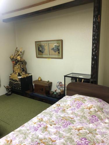 een slaapkamer met een bed en een foto aan de muur bij Guest House Kizuna in Oshamambe