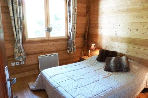 a bedroom with a bed in a wooden room at Chalet centre village, 8 personnes, 4 chambres - CH25 in Beaufort