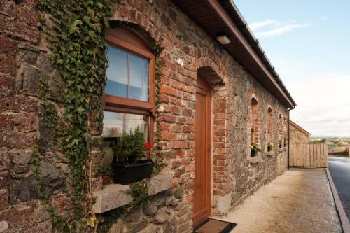 a brick building with a window and plants on it at Drumnavaddy Cottage Banbridge, Dromore, County Down in Dromore