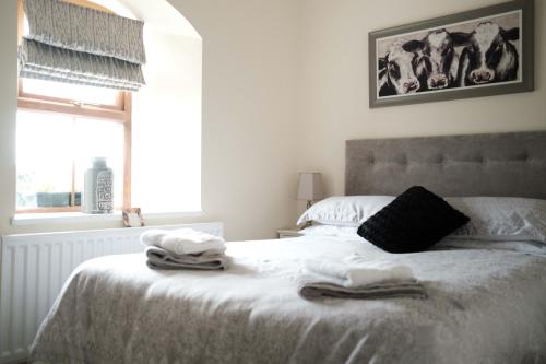 ein Schlafzimmer mit einem Bett mit Handtüchern darauf in der Unterkunft Drumnavaddy Cottage in Dromore