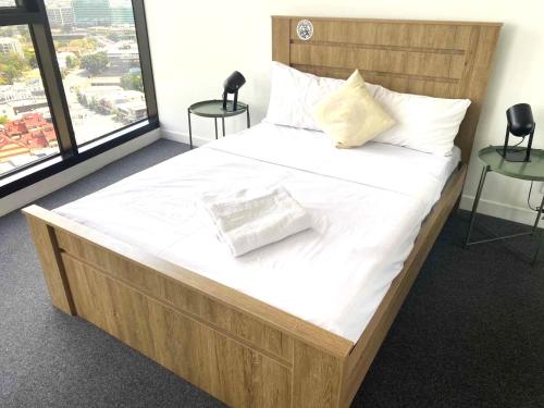 1 cama grande con sábanas blancas y almohadas. en KOZYGURU FORTITUDE VALLEY HIGH LEVEL 2 BED APT + FREE PARKING QFV179-2612 en Brisbane