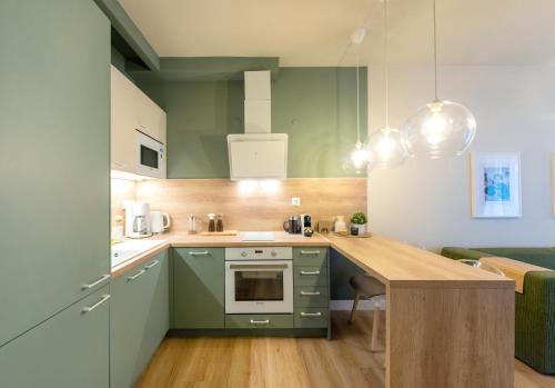 a kitchen with green cabinets and a wooden table at Mandarin apartments by halu! in Thessaloniki