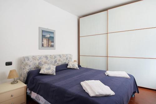a bedroom with a blue bed with towels on it at Beach Paradise- Luigi 16 in Levanto