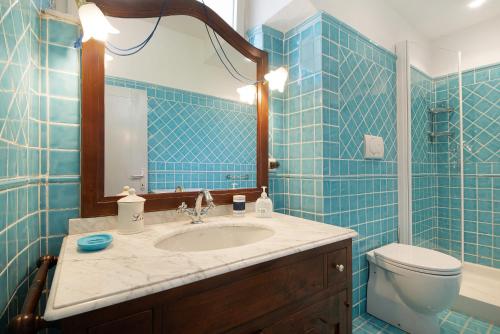a blue tiled bathroom with a sink and a toilet at Beach Paradise- Luigi 16 in Levanto