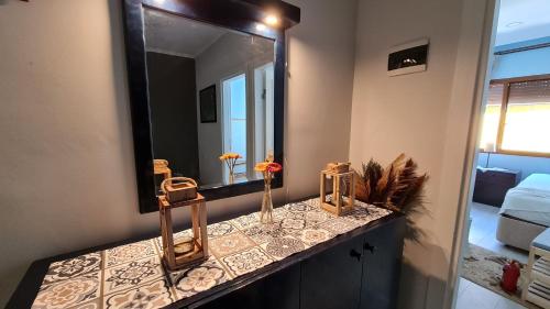 a bathroom with a mirror and a counter with flowers on it at Condo Reina, Kusadasi in Kusadası
