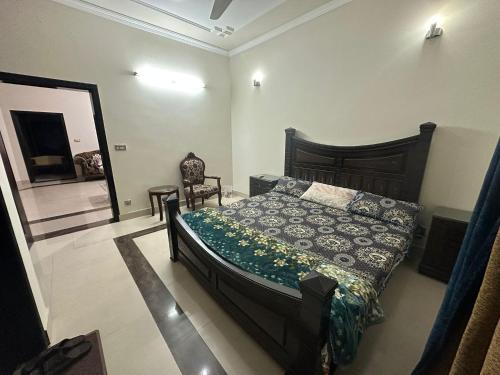 um quarto com uma cama e uma cadeira em Bahria Town - 10 Marla 2 Bed rooms Portion for families only em Lahore