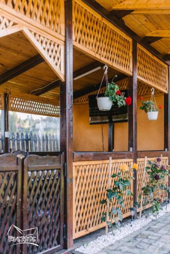 a wooden building with two potted plants on it at Riverside • cabine in Gălăuţaş