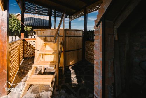 a wooden ladder sitting next to a wooden tub on a porch at Riverside • cabine in Gălăuţaş