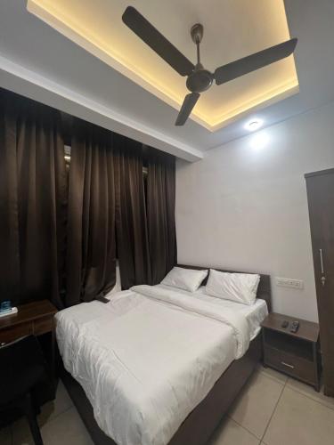 a bedroom with a bed and a ceiling fan at AROMA INN in Kalpetta