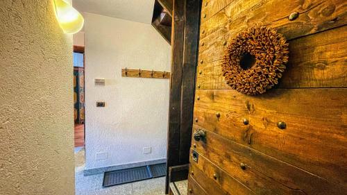 una pared de madera con una corona junto a una puerta en Appartamento Jouvenceaux 40 - Affitti Brevi Italia, en Sauze dʼOulx