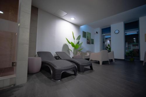 a waiting room with benches and tables in a building at Eleven Business & Sport Hotel in Jászárokszállás