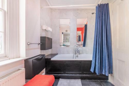 een badkamer met een zwart bad en een spiegel bij Luxury 3 bedroom Flat Trafalgar Square, Embankment, Waterloo in Londen