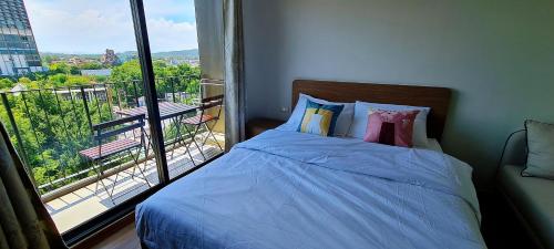 a bedroom with a bed and a large window at Highest Floor Close to Cicada and Tamarind Night Market Lahabana Condo หัวหิน ลาฮาบาน่า คอนโด ชั้นบนสุด ติดกับตลาดซิเคด้าและตลาดแทมมารีน in Hua Hin