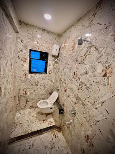 a dirty bathroom with a toilet and a window at Hotel Rahul Regency, Aurangabad in Aurangabad