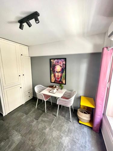 una stanza con tavolo e sedie e un dipinto sul muro di Mini Suite Home a Alexandroupoli