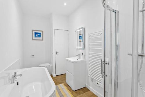 a white bathroom with a sink and a toilet at Landau Apartment, Stokenham in Stokenham