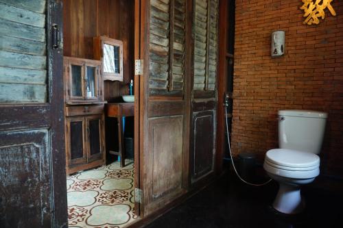 un baño con inodoro y lavabo en Traditional Lanna house near hot spring, en Chiang Dao