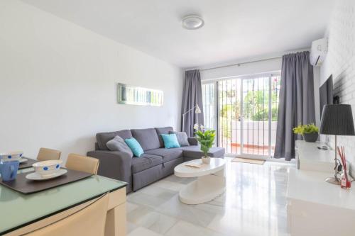 een woonkamer met een bank en een tafel bij Apartamento Viveros Marbella in Marbella