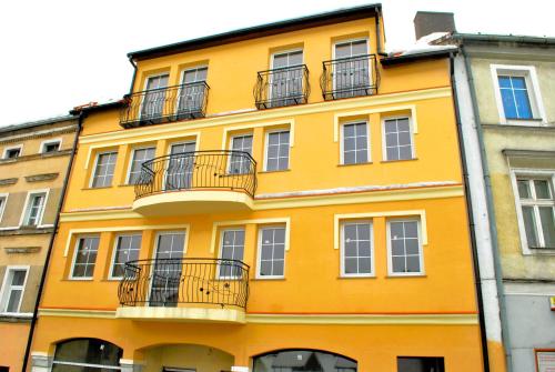a yellow building with balconies on the side of it at Apartament w Kamienicy na Kłodzkiej in Duszniki Zdrój