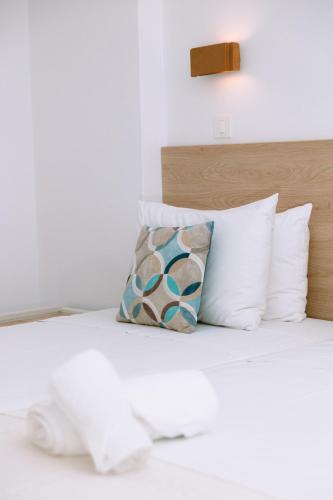 a bedroom with a bed with white pillows at Santa Marina Unique Hotel in Agios Nikolaos
