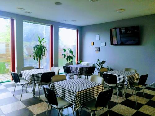 comedor con 2 mesas, sillas y ventanas en Akademia Tenisa Prawobrzeże, en Szczecin