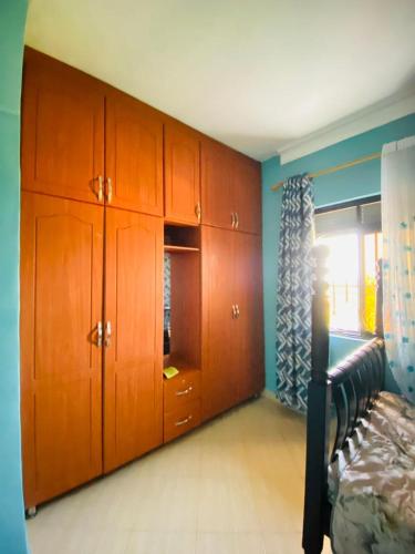 ein Schlafzimmer mit Holzschränken und einem Bett darin in der Unterkunft Blessings apartment buziga in Kampala