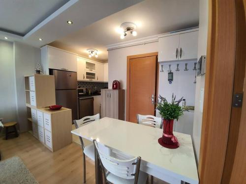 a kitchen with a white table and white chairs at Cozy 3 Room Duplex With Terrace in Istanbul