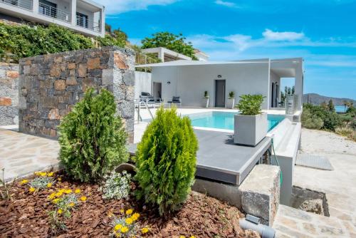 a villa with a swimming pool and a house at Elounda Sunshine Place in Elounda