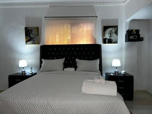 1 dormitorio con 1 cama grande, 2 lámparas y ventana en Apartamento entero Tu Nido De Amor 2 Santo Domingo oeste, en Santo Domingo